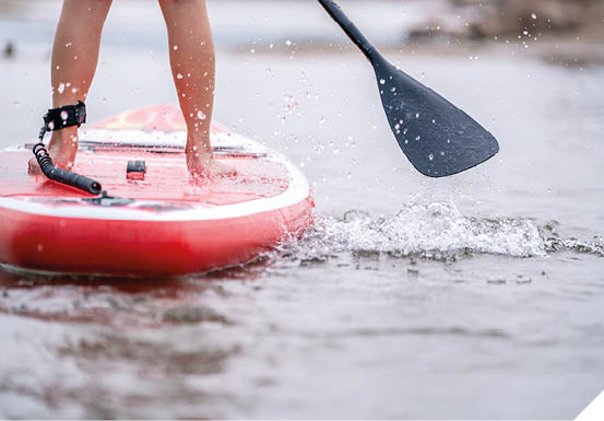 close-up of legs Stand up paddle boarding on the river 